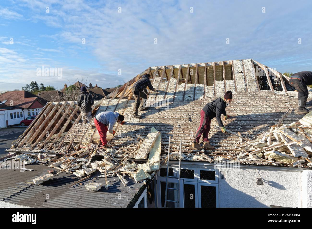 Builders removing hardened spray foam insulation from the roof space of