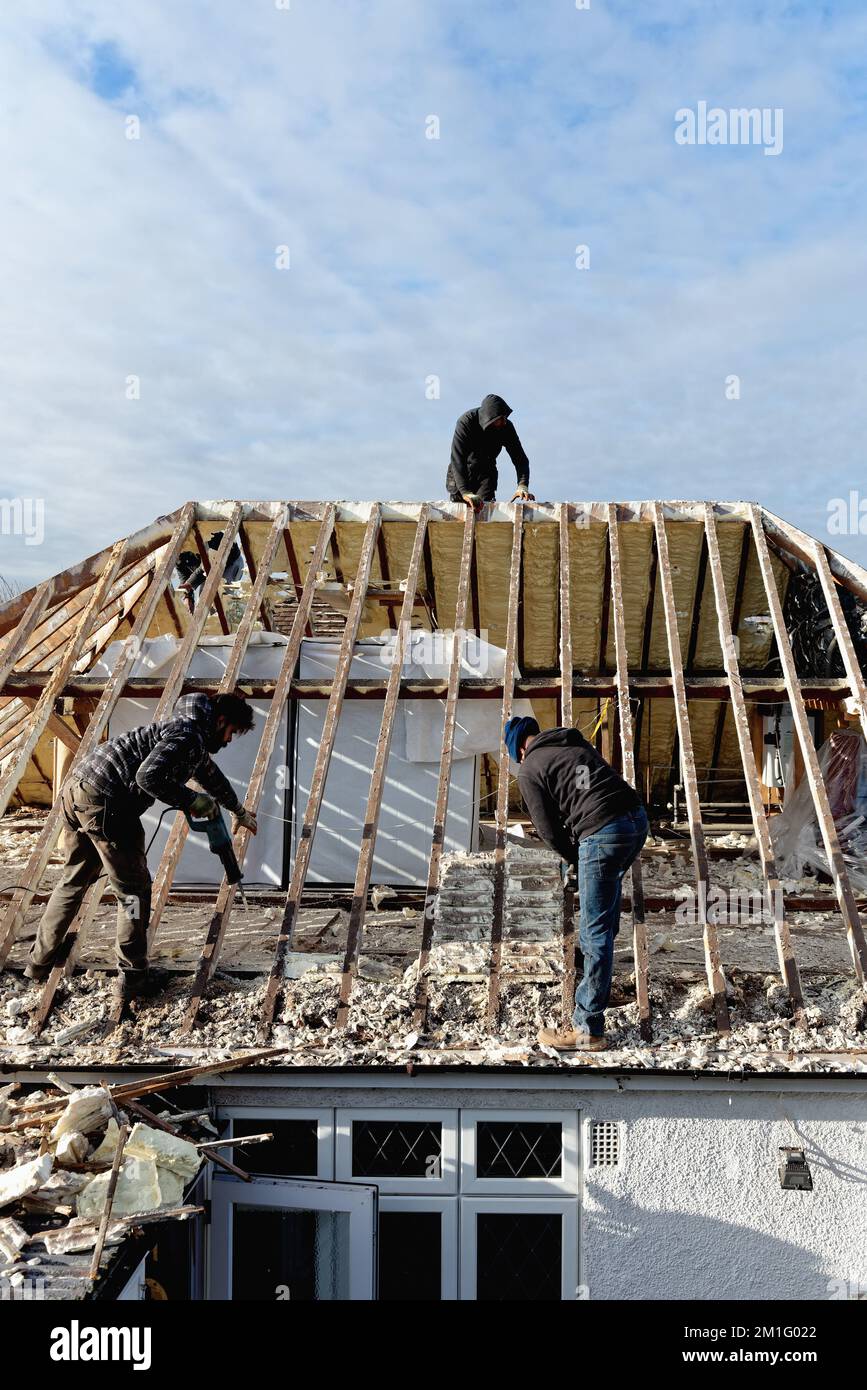 Builders removing hardened spray foam insulation from the roof space of