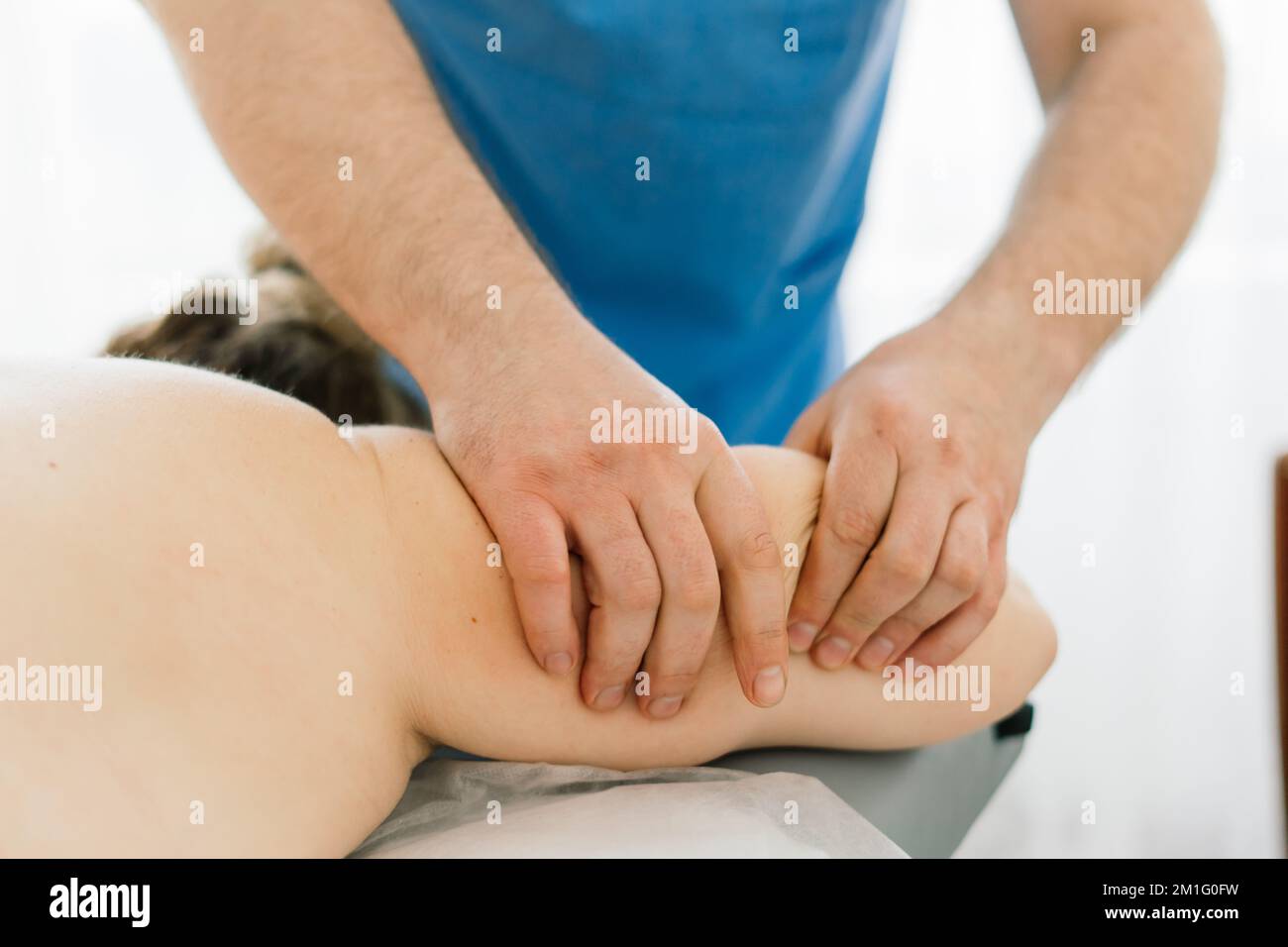 Young fat woman getting massage treatment in day spa cabinet. Stock Photo