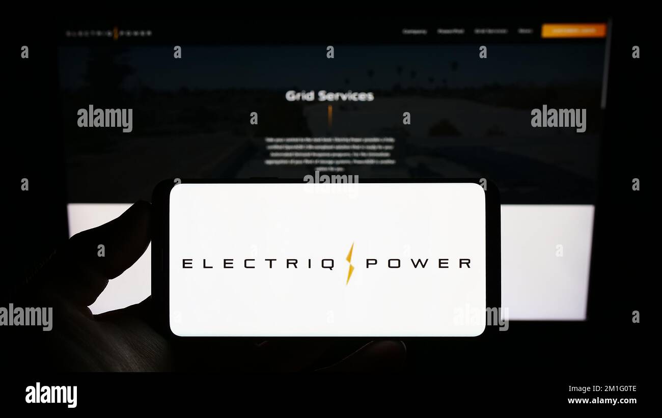 Person holding smartphone with logo of US energy storage company Electriq Power Inc. on screen in front of website. Focus on phone display. Stock Photo