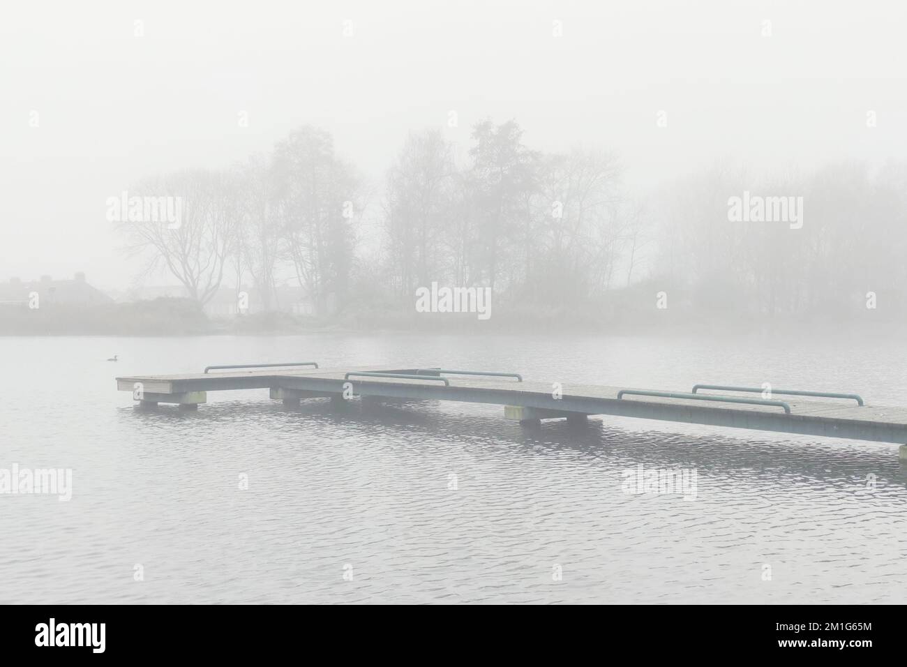 Jetty in the water of a lake in foggy conditions Stock Photo