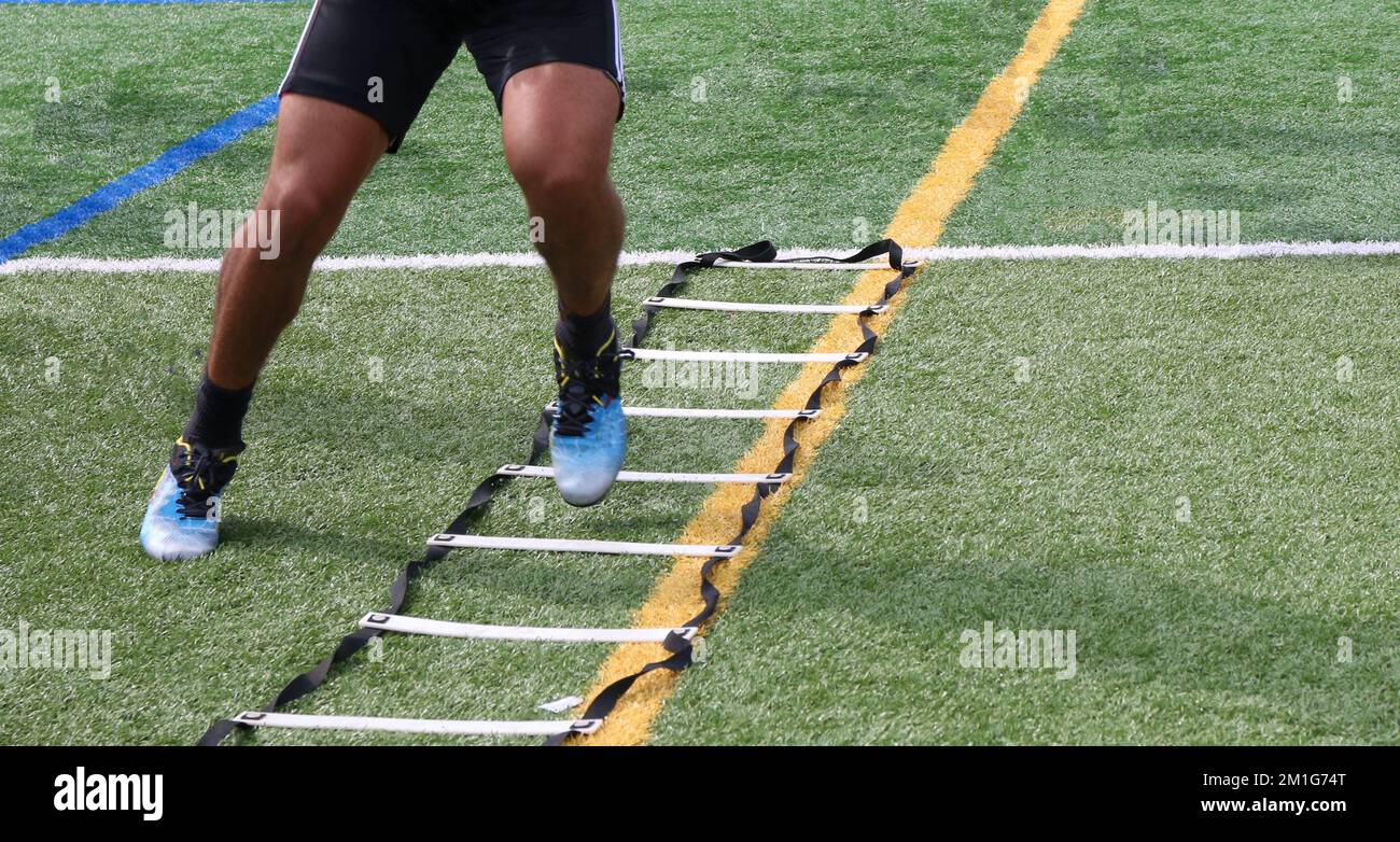 Legs of an athlete running side to side in a football ladder drill