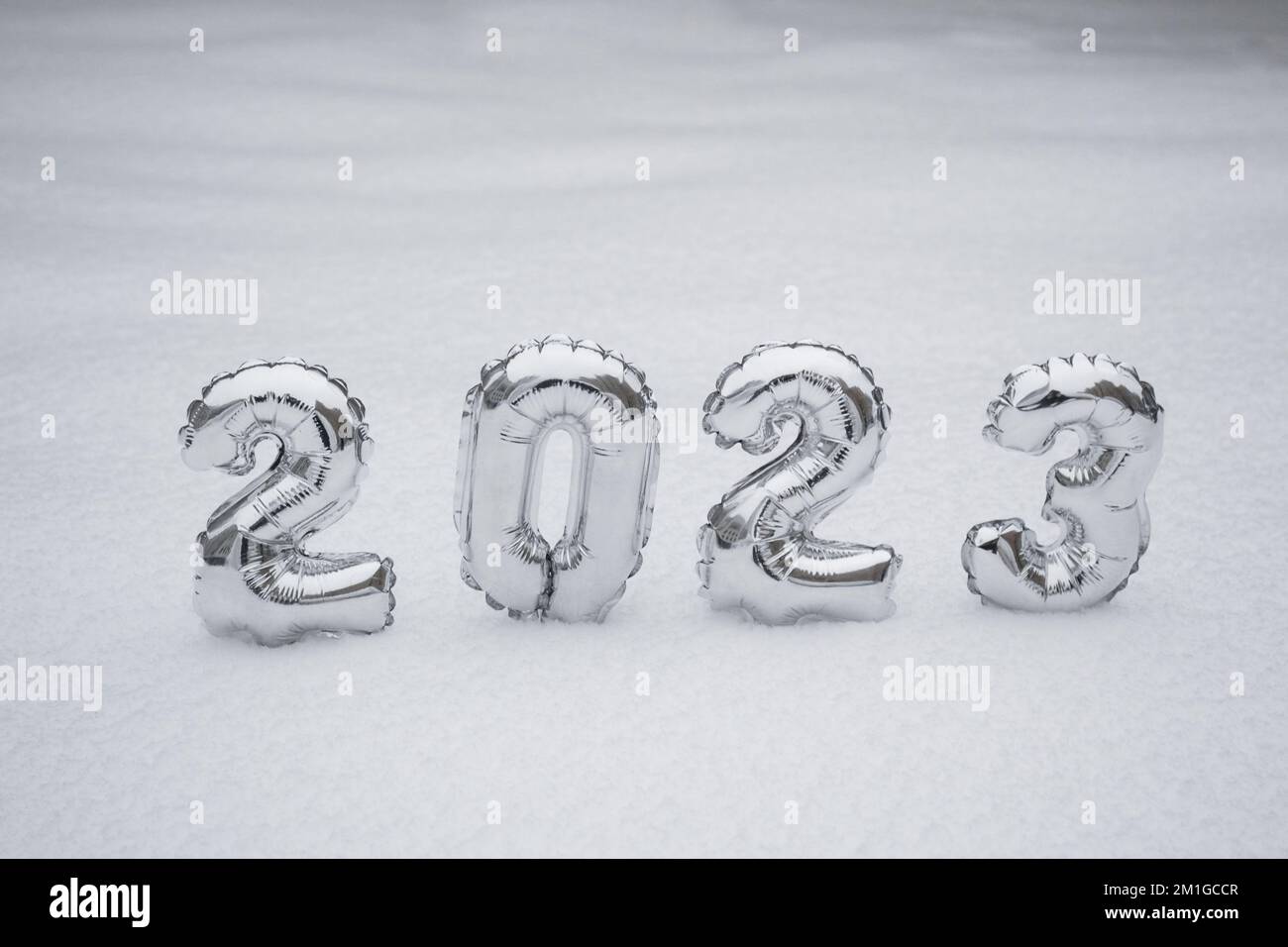 Silver numbers of the New Year 2023, in winter on a background of white snow with copy space. Stock Photo