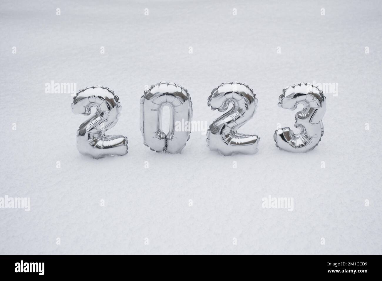 Silver numbers of the New Year 2023, in winter on a background of white snow with copy space. Stock Photo