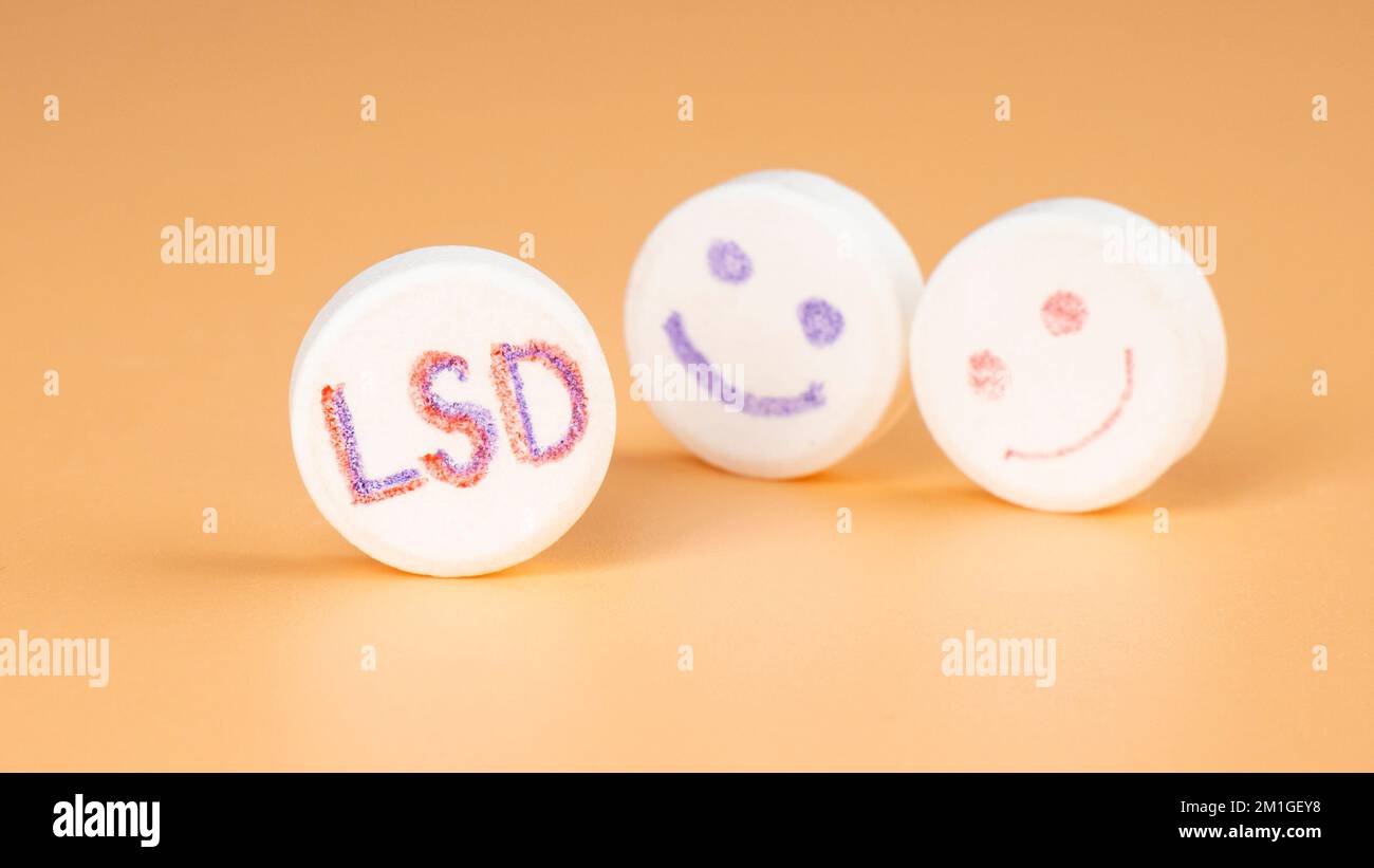 lsd pill closeup on beige background, psy tablet for trip. Stock Photo