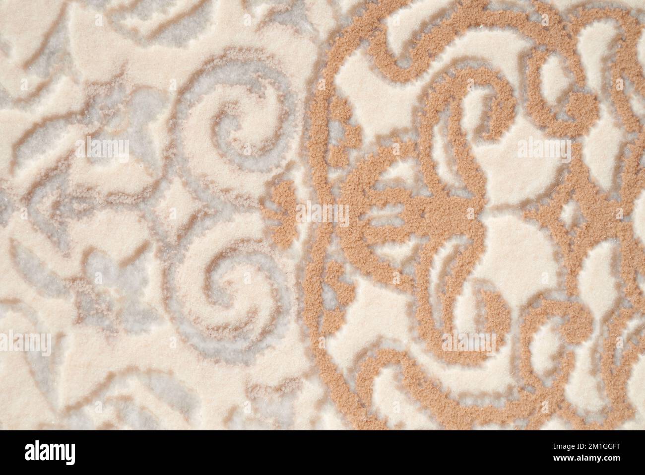 Fragment of decorative carpet fabric pattern, background photo texture. Close up of geometric beige and white short pile carpet ornament. Backgrounds and textures concept. Stock Photo