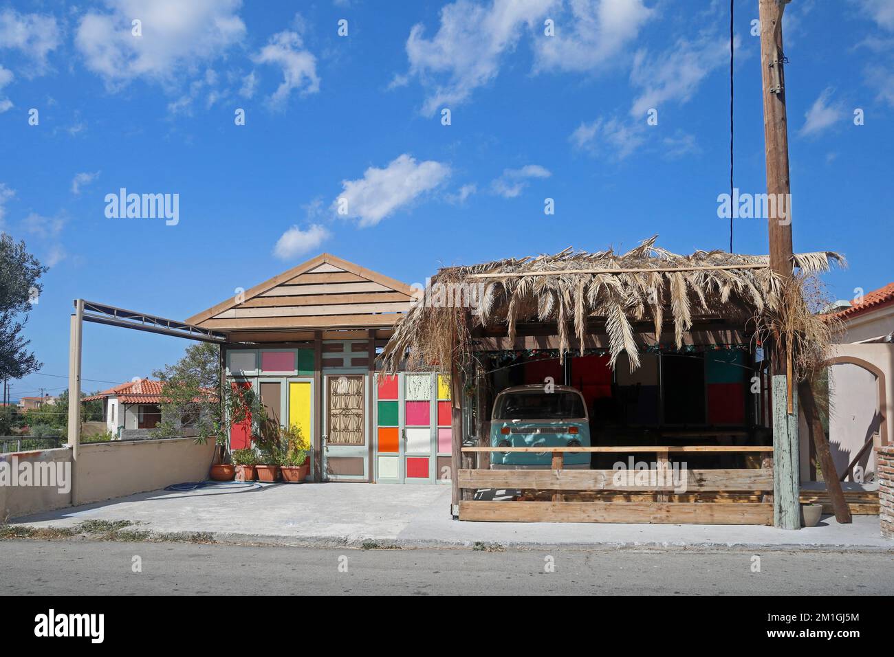Small colourful shack style cafe (closed at end of season) and VW camper van parked inside, Lesbos. Taken September / October 2022. Stock Photo