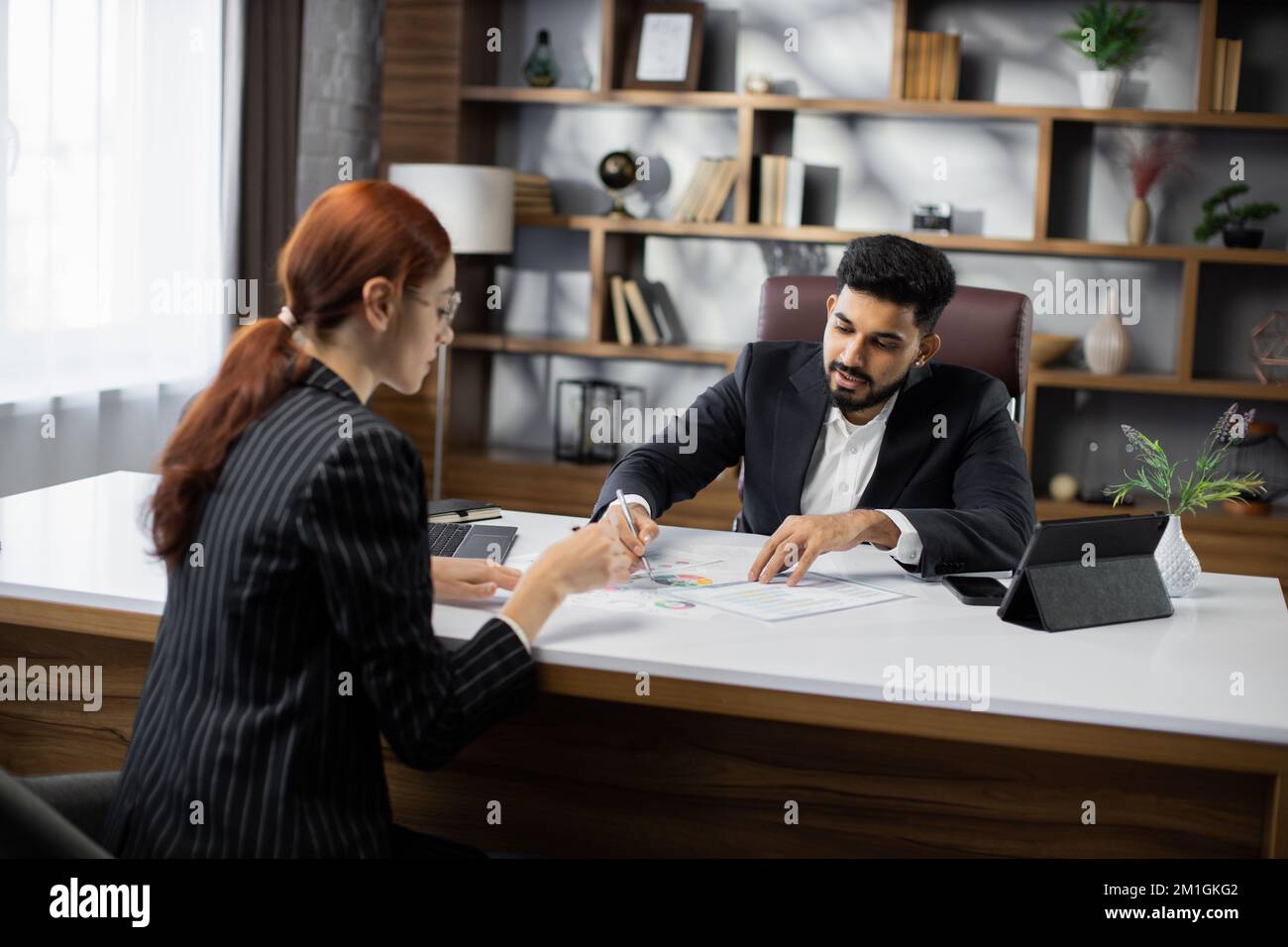 Back view of two business people, man and woman, representing sides of