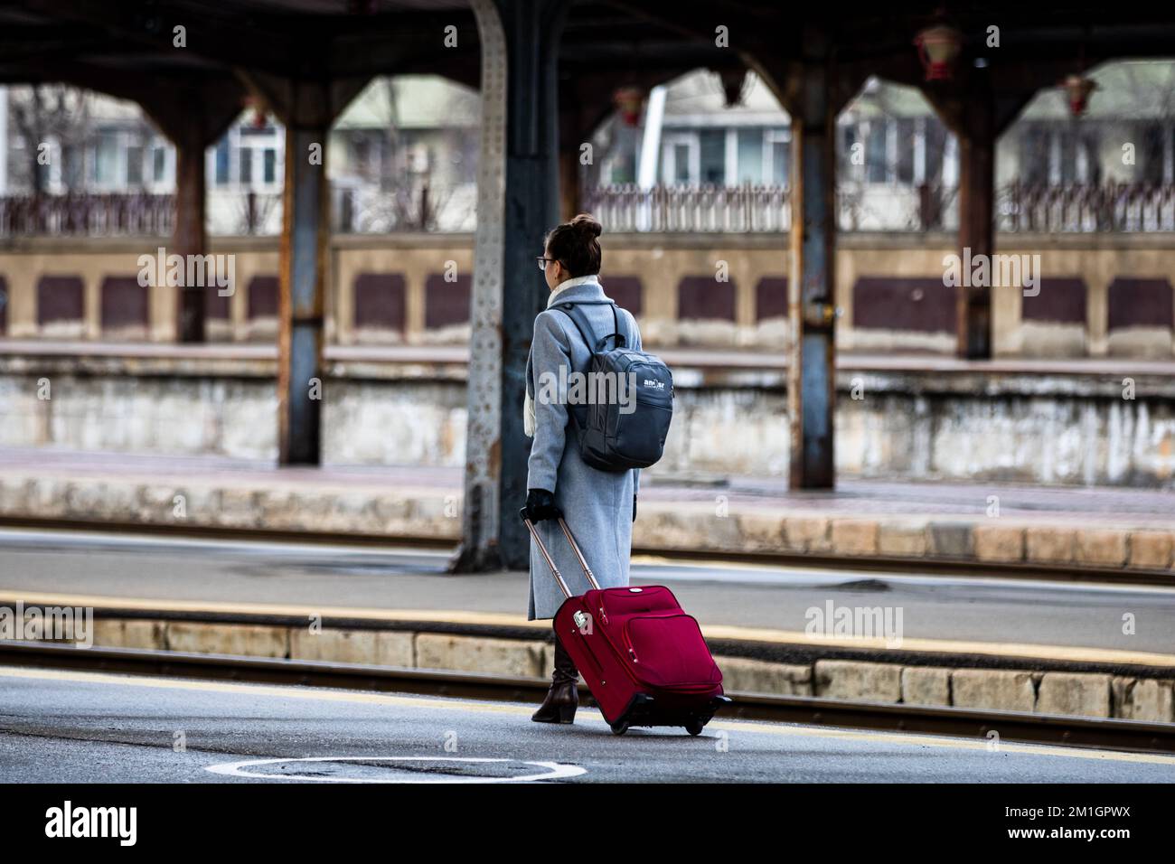 Tourist pulling luggage. Commuters walking at railroad station platform in Bucharest, Romania, 2022 Stock Photo