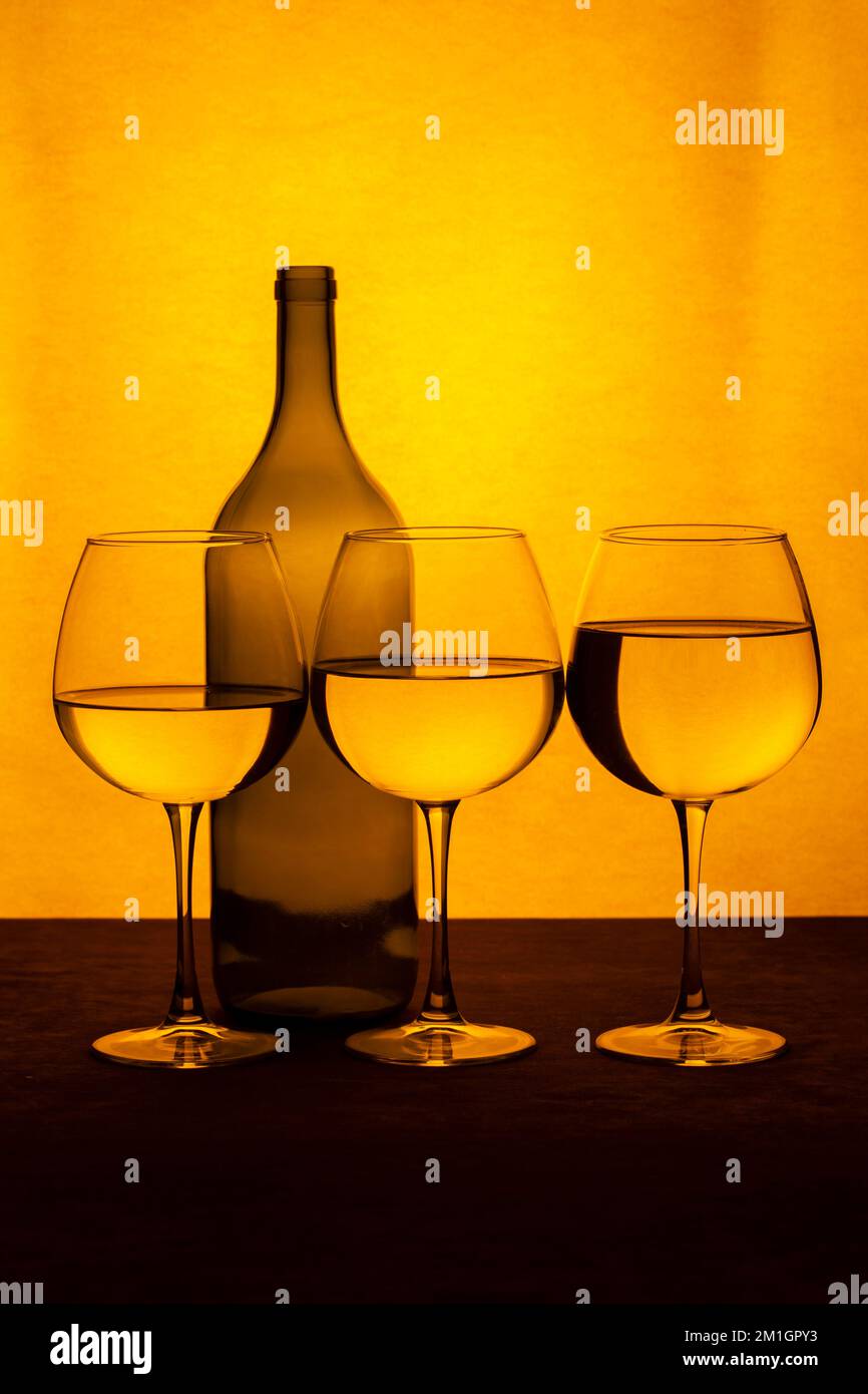Still life with a wine bottle and glasses with liquid Stock Photo - Alamy