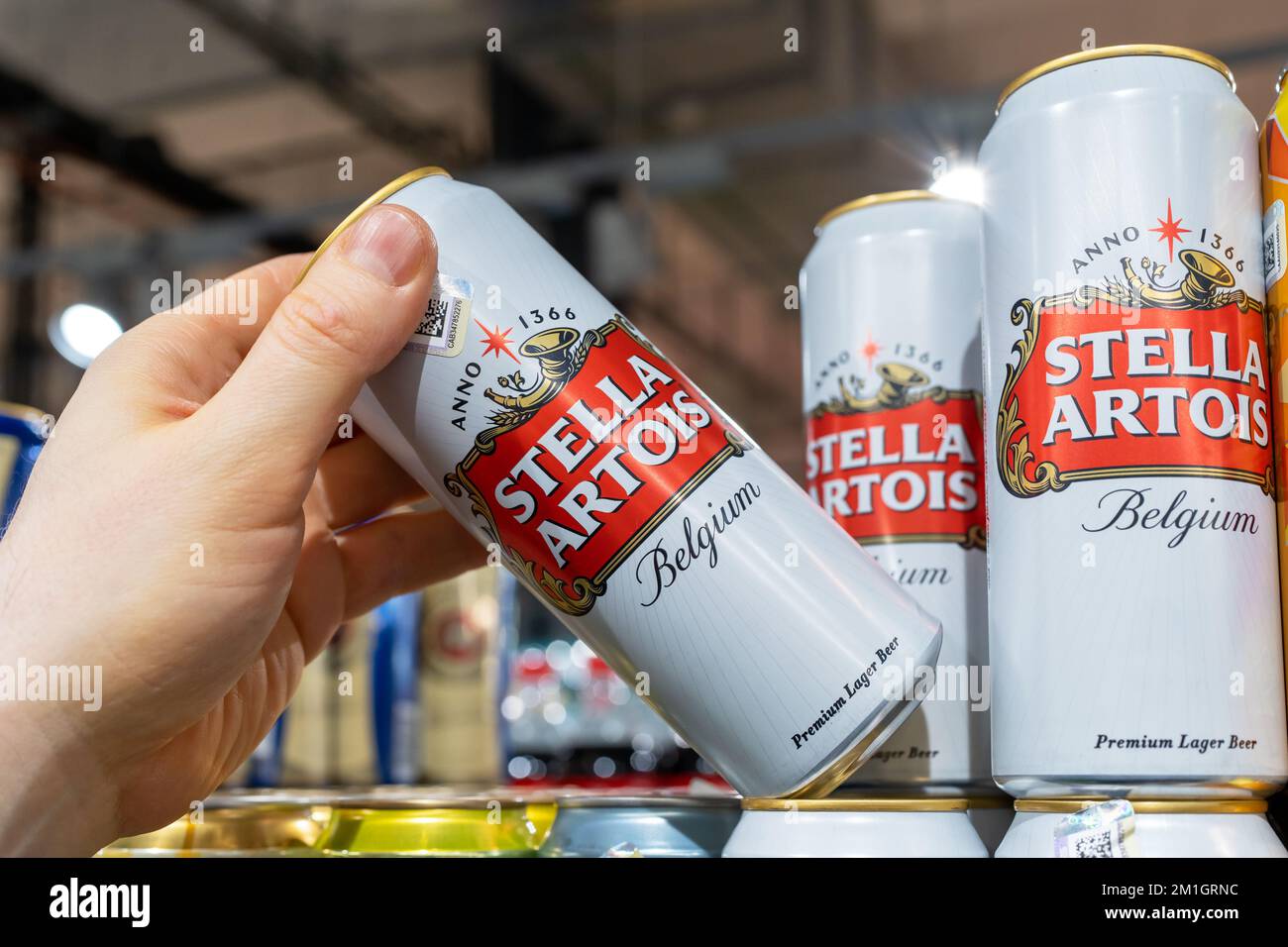 Man's hand is holding Stella Artois beer can from supermarket shelf. Minsk, Belarus, 2022 Stock Photo
