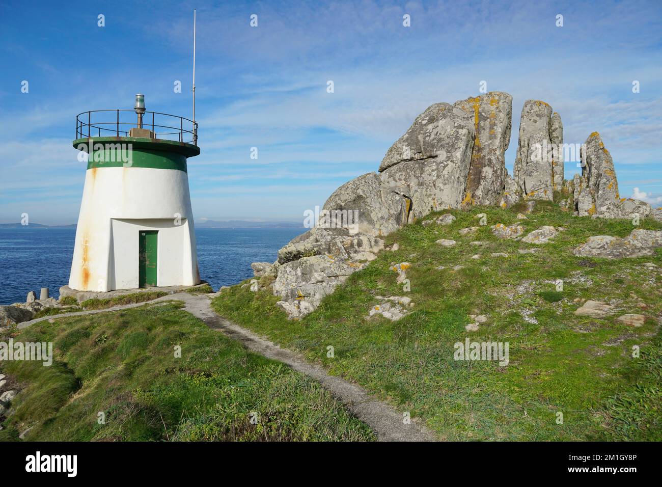 Lighthouse with rock formation on the coast of Galicia in Spain, Pontevedra province, Cangas, Rias Baixas Stock Photo