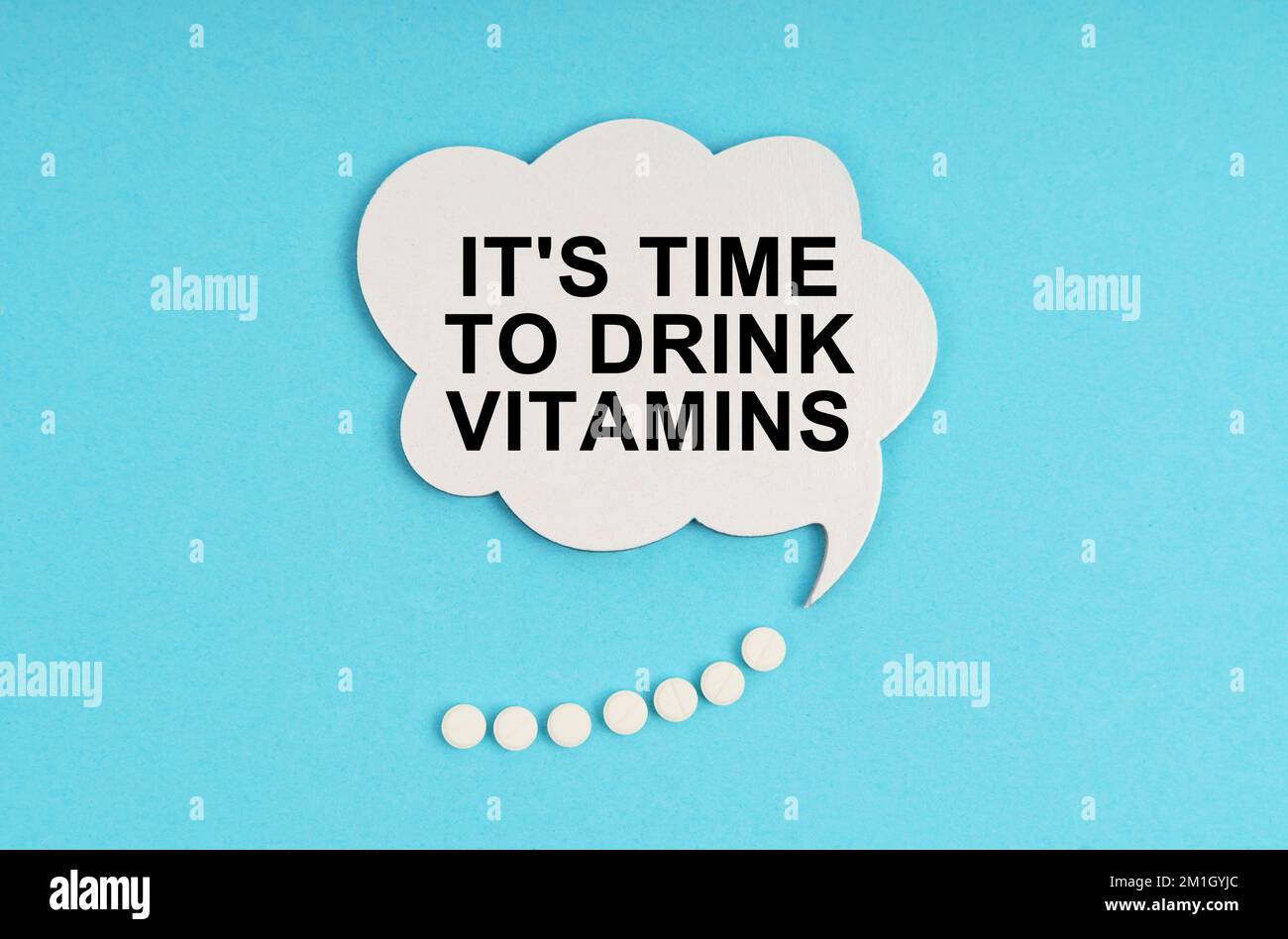 Medicine and health concept. On a blue table are pills and a white plate with the inscription - It s time to drink vitamins Stock Photo