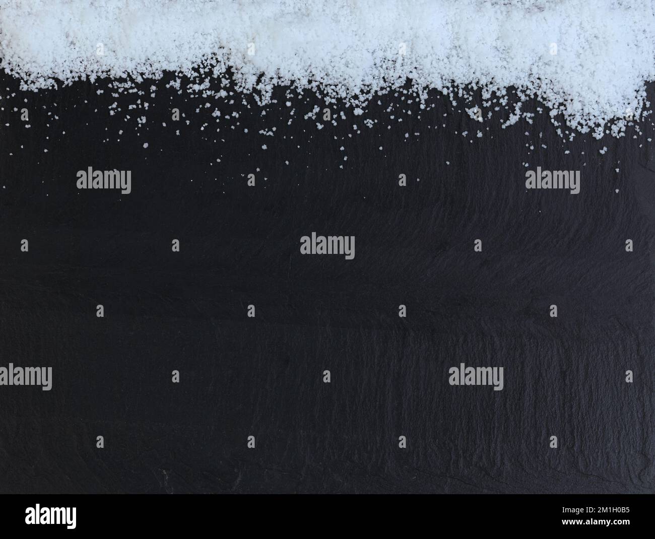 Border of Christmas snow on dark stone background Stock Photo