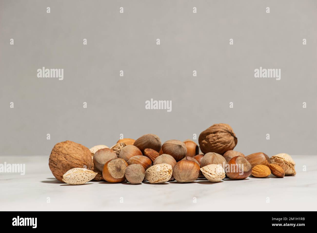 A handful of different nuts on a gray background Stock Photo