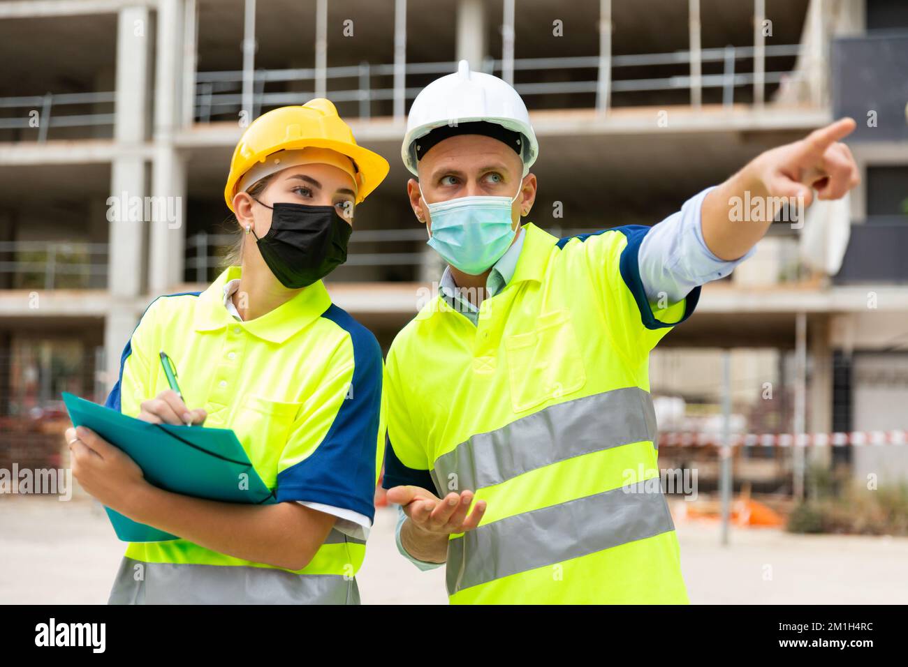 Civil engineers in masks checking work process Stock Photo
