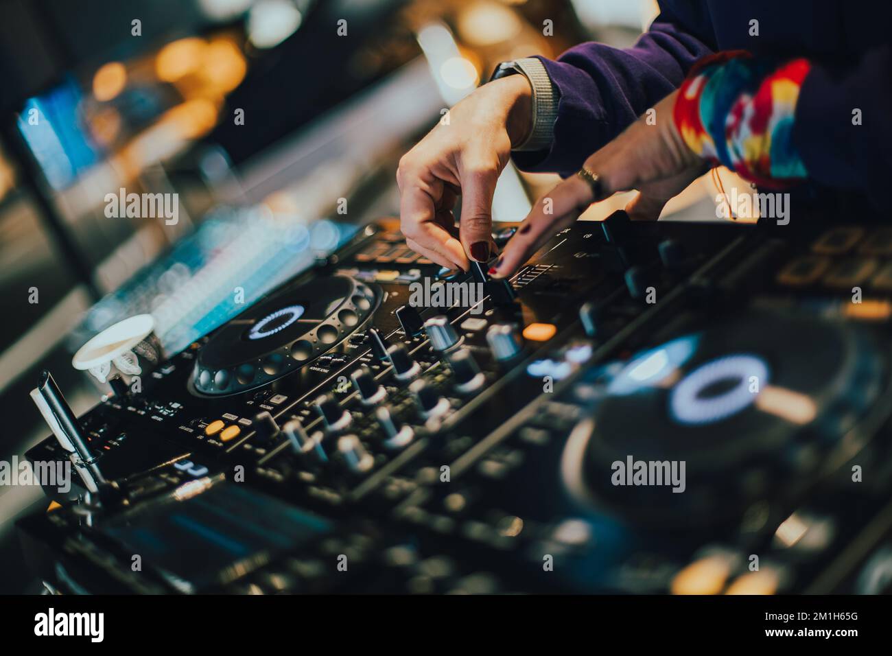 DJ plays live set and mixing music on turntable console on stage at