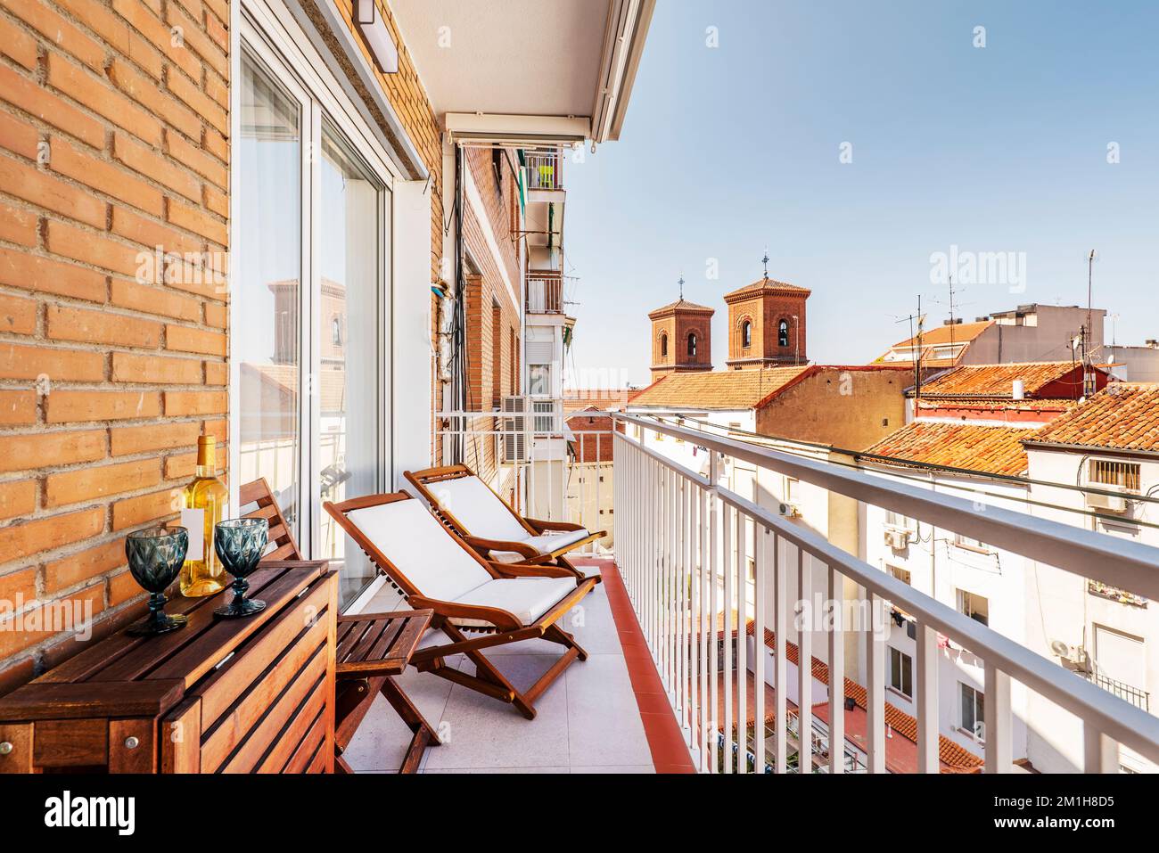 Balcony with wooden and fabric armchairs, a folding table of the same ...