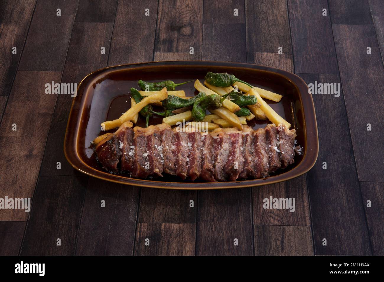 a filleted roast pork loin with green peppers and fries Stock Photo Alamy