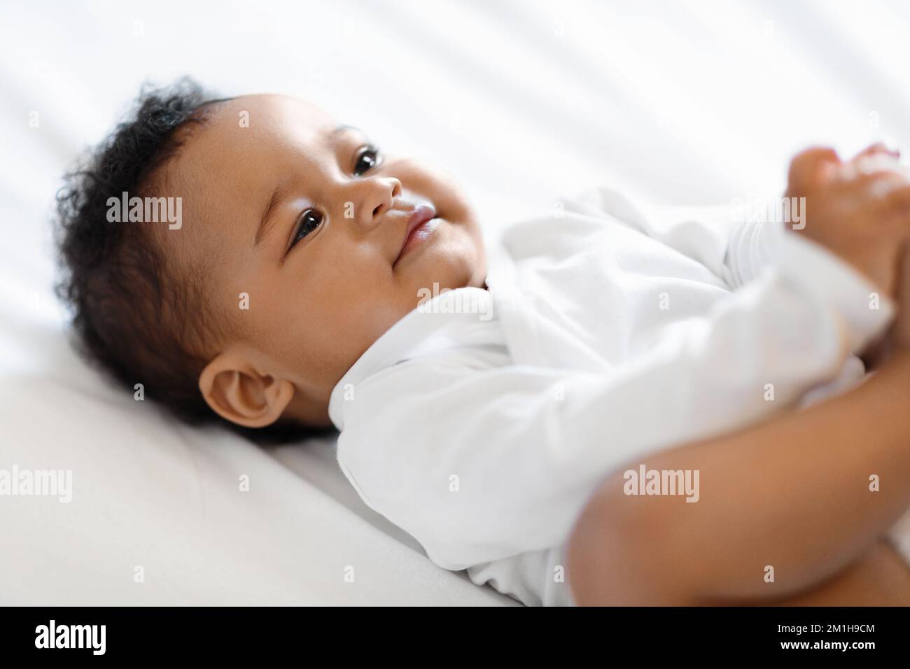 Closeup Of Cute Little Black Baby Boy Of Girl Lying On Bed Stock Photo -  Alamy