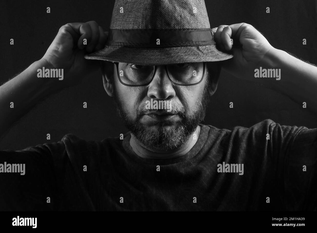 Black and white portrait of a man wearing a hat and glasses. Isolated ...