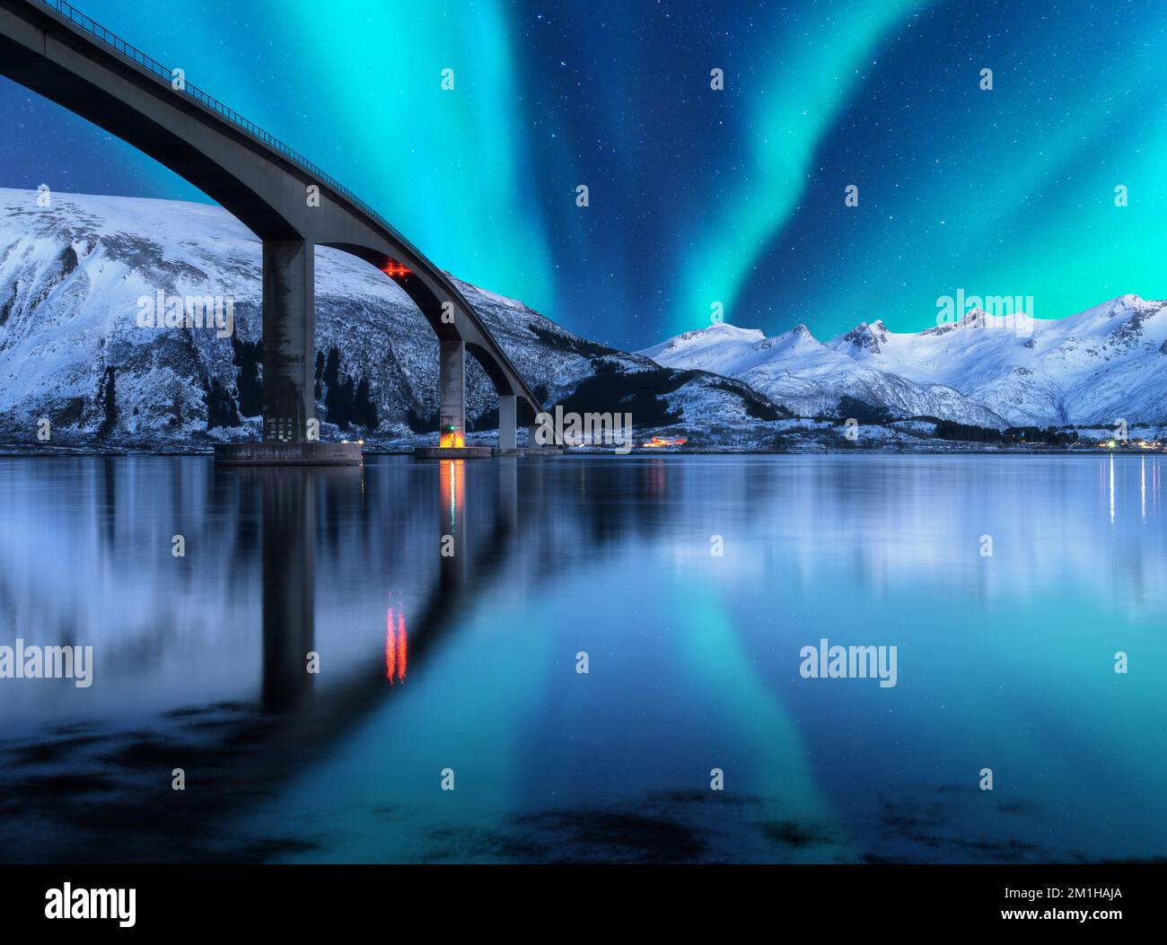 Bridge And Aurora Borealis Over Snowy Mountains Lofoten Islands Stock bridge-and-aurora-borealis-over-snowy-mountains-lofoten-islands-stock