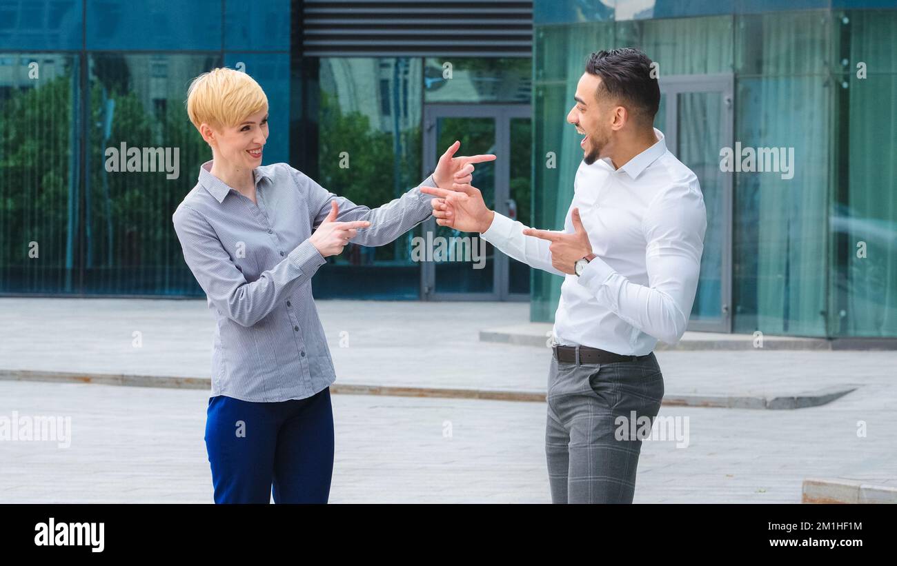 Multiracial couple business colleagues arabic spaniard man manager boss and caucasian adult blonde woman standing outdoors talking actively gesturing Stock Photo