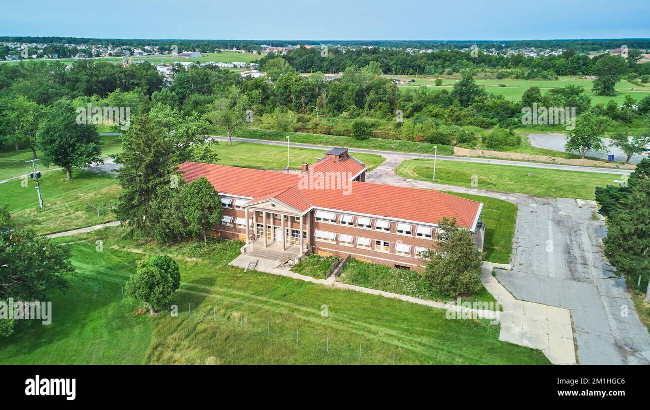 Aerial of stunning abandoned brick building with stone pillar entrance