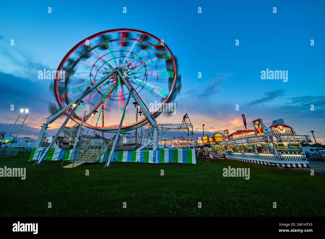 Blurred ferris wheel at American summer county fair during dusk Stock