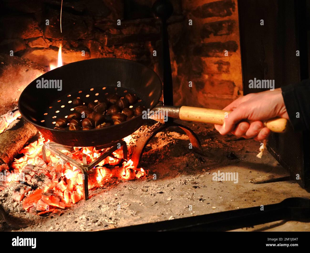 Person roasting chestnuts over fire Stock Photo Alamy