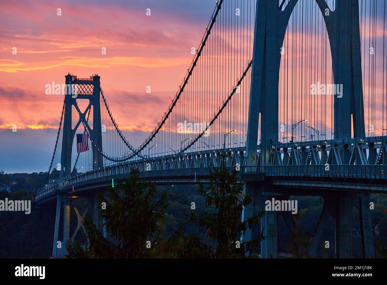 Beautiful Mid-Hudson bridge in New York during sunrise with American Flag Stock Photo