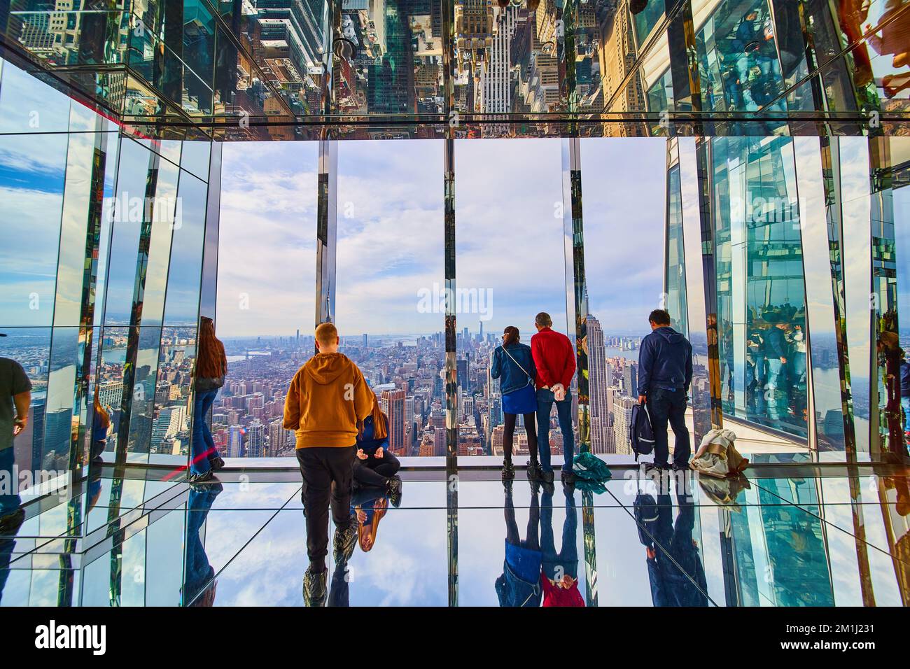 Glass mirror room overlook with tourists high up over New York City looking at Manhattan skyline