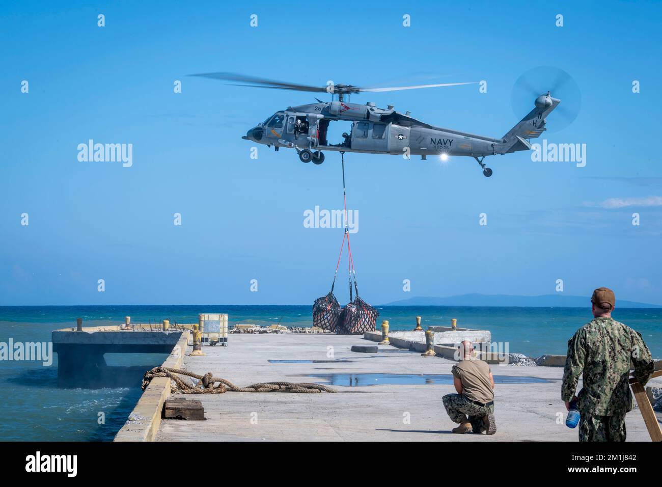 Sailors assigned to the “Chargers” of Helicopter Sea Combat Squadron (HSC) 26, deliver supplies from the hospital ship USNS Comfort (T-AH 20) to the medical site in Jeremie, Haiti, during Continuing Promise 2022, Dec. 11, 2022. Comfort is deployed to U.S. 4th Fleet in support of CP22, a humanitarian assistance and goodwill mission conducting direct medical care, expeditionary veterinary care, and subject matter expert exchanges with five partner nations in the Caribbean, Central and South America. (U.S. Navy photo by Mass Communication Specialist 1st Class Benjamin Lewis) Stock Photo