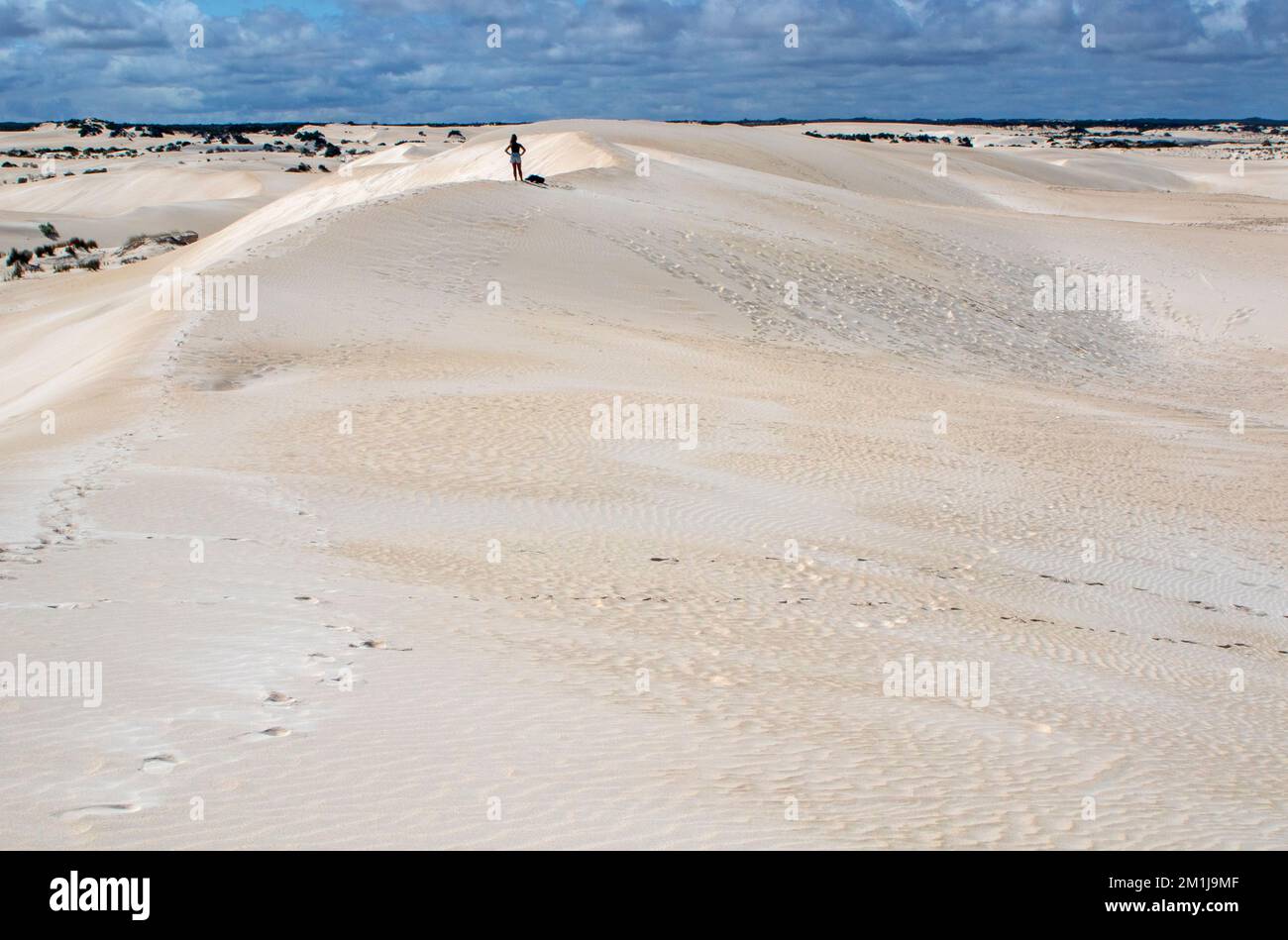 Woman atop the sand dunes at Lancelin Stock Photo