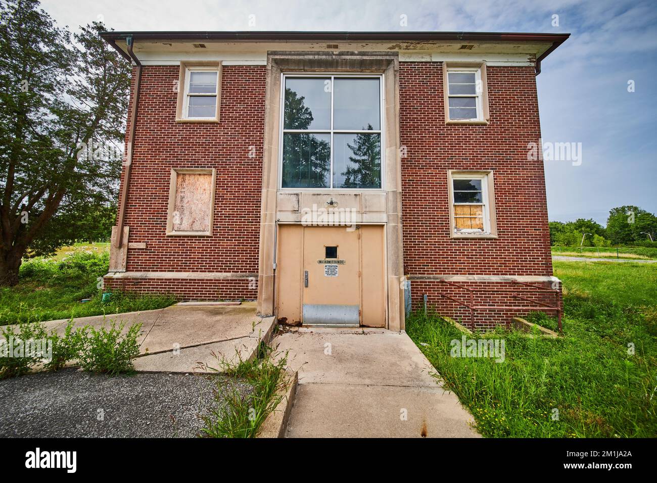 Abandoned brick building from exterior with overgrown grass Stock Photo ...