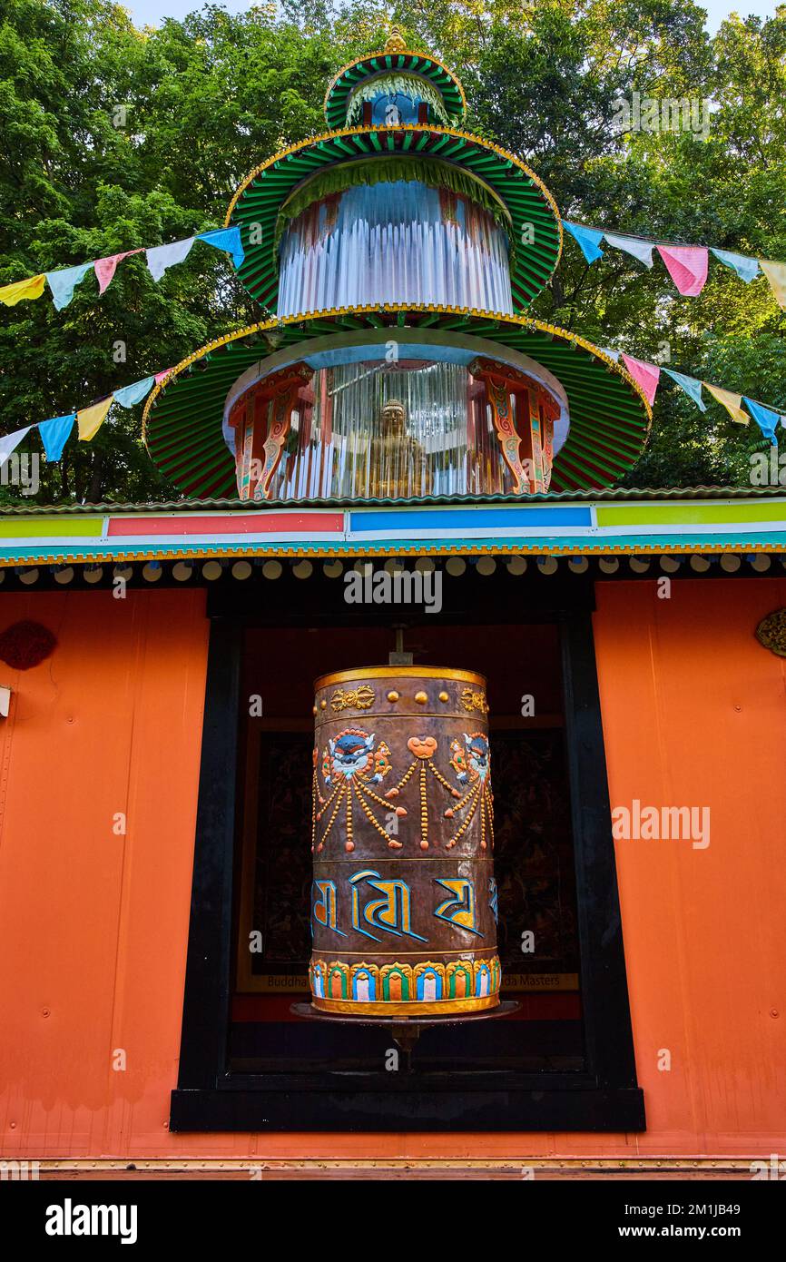 Large ornate prayer wheel and prayer flags for Tibetan Mongolian Buddhist temple Stock Photo