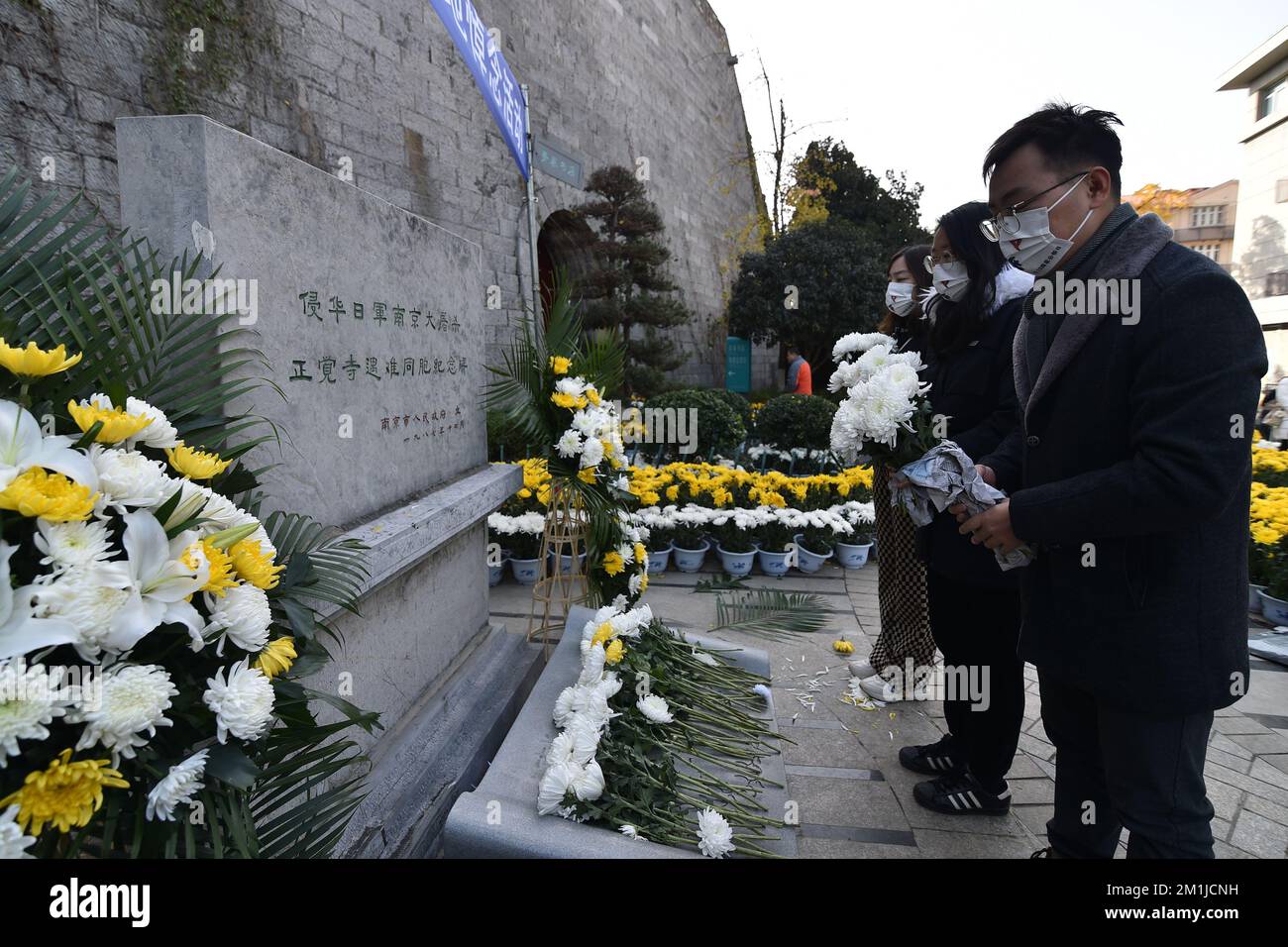 NANJING, CHINA - DECEMBER 13, 2022 - People present flowers at a memorial monument for the victims of the Nanjing Massacre by Japanese invaders at Zhe Stock Photo