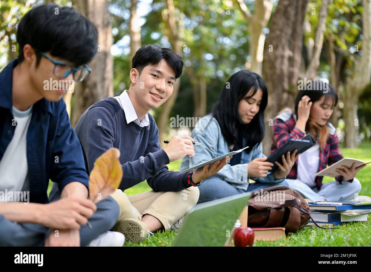 Handsome and smart young Asian male college student using his portable ...
