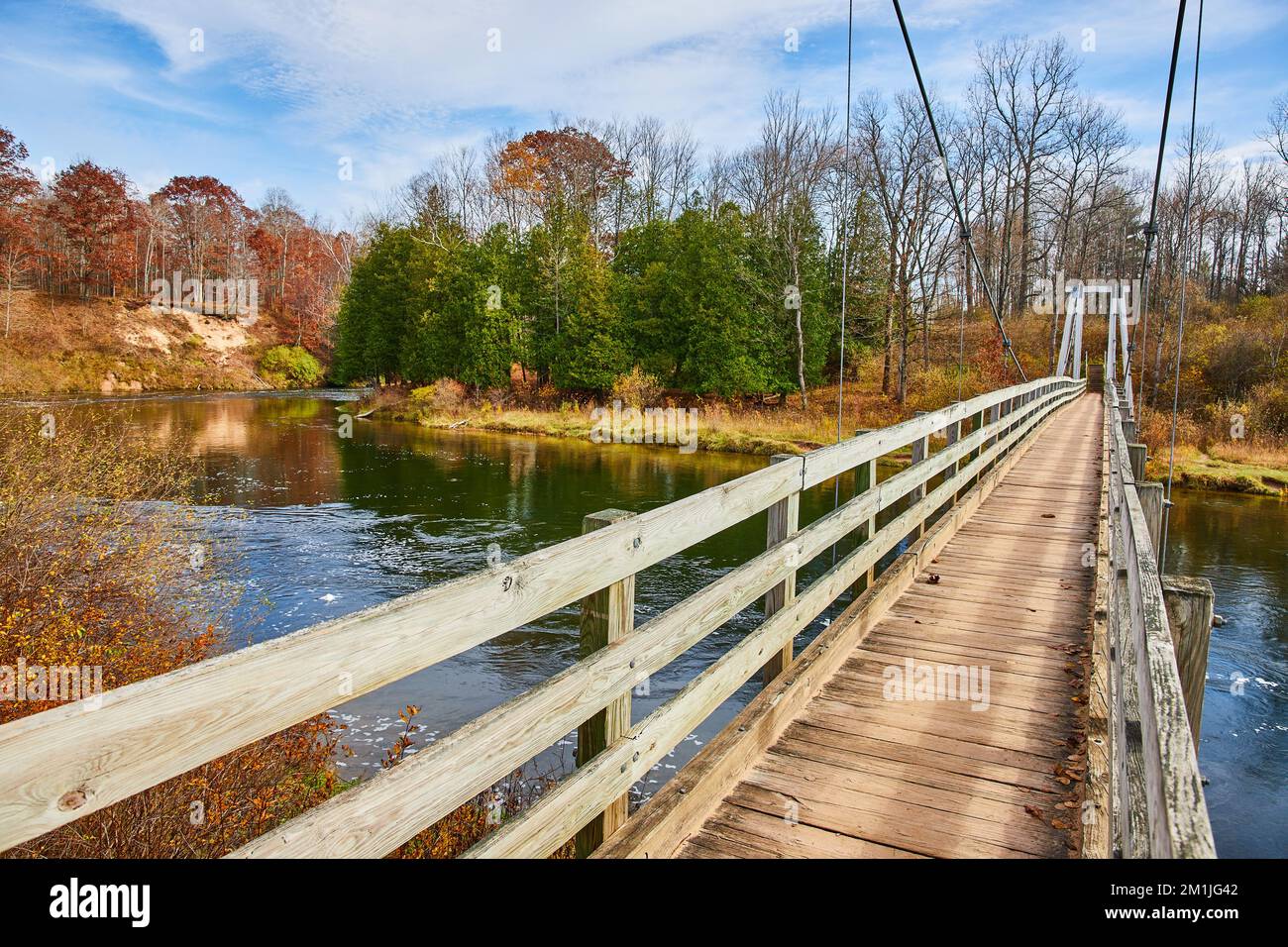 Manistee River Trail suspension bridge in late fall over river Stock