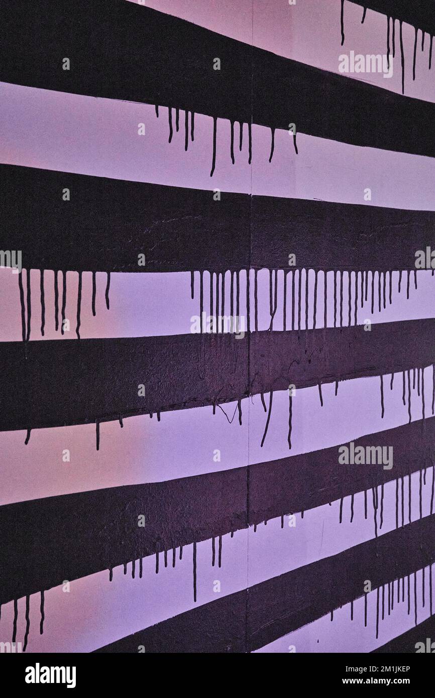 Black and white stripes on wall with dripping black paint Stock Photo