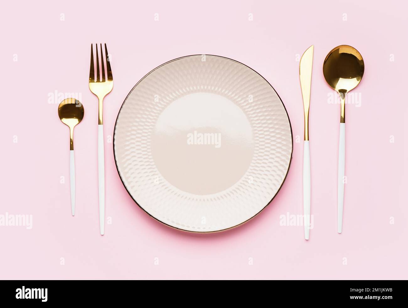 White plate and cutlery on pink background Stock Photo - Alamy