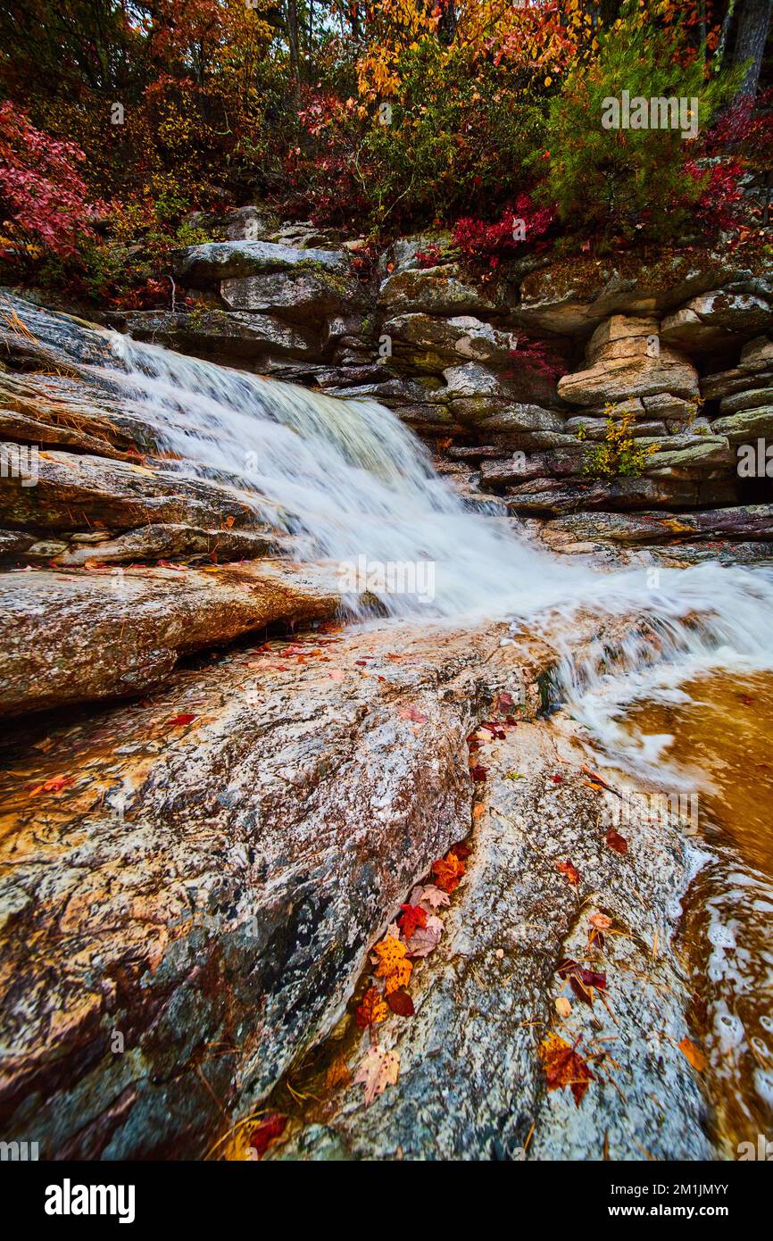 Waterfall up close with exposed rocks and fall leaves Stock Photo