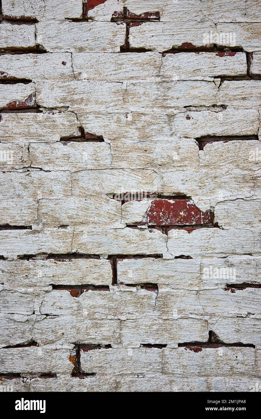 Red brick wall painted white with cracking paint and one exposed red brick Stock Photo Alamy