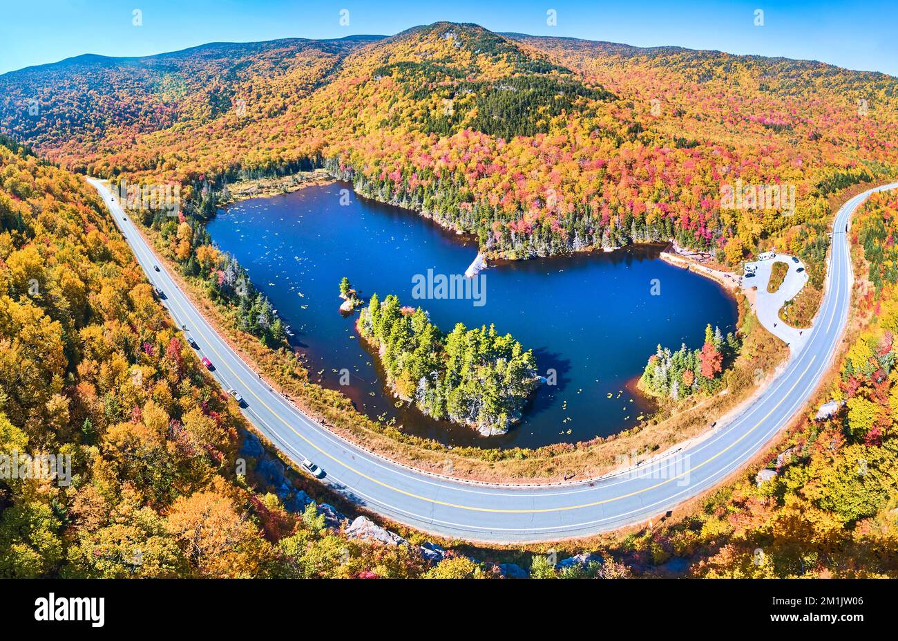 Wide panorama aerial over highway through stunning peak fall foliage