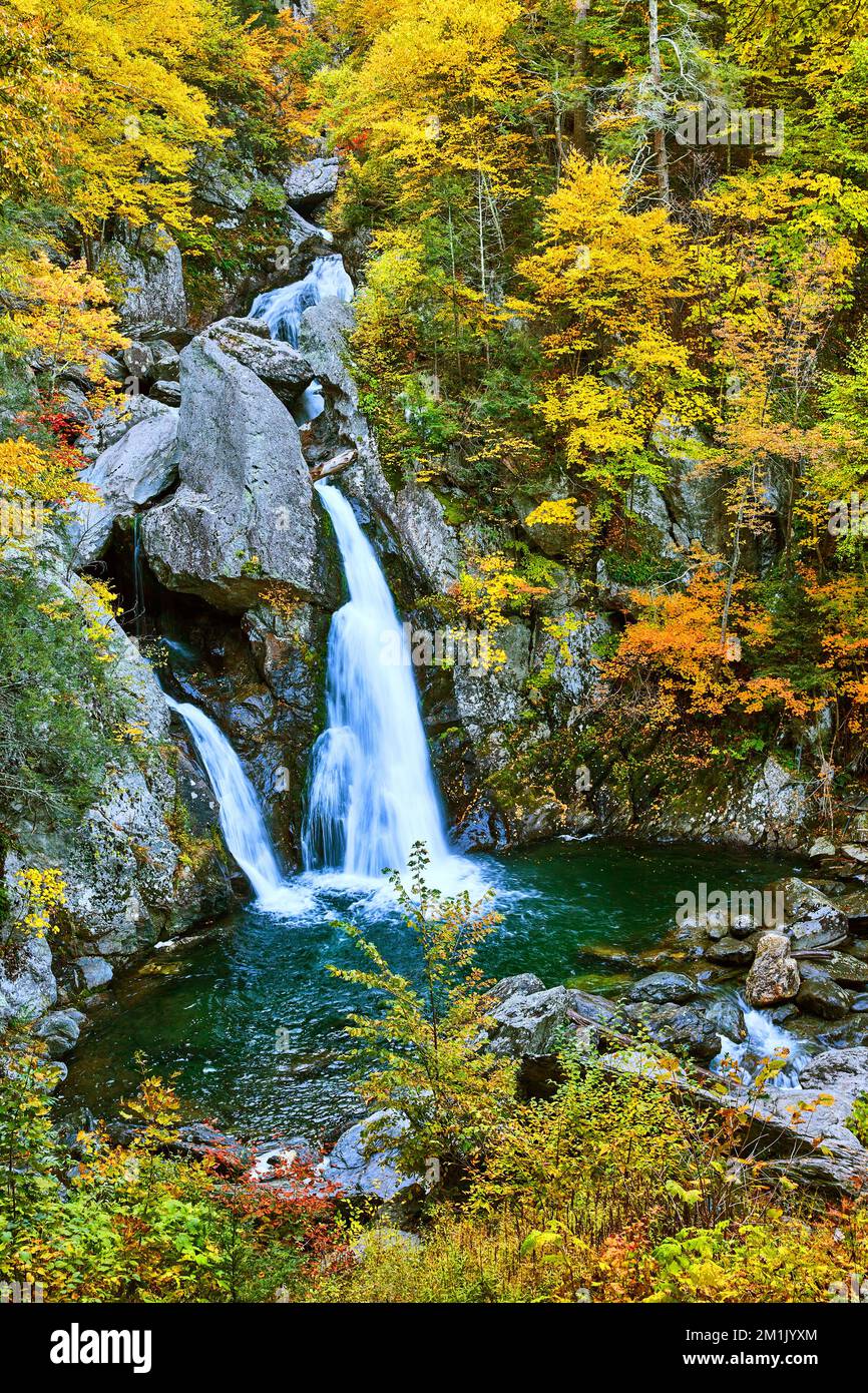 Stunning Upstate New York waterfall surrounded by yellow fall foliage