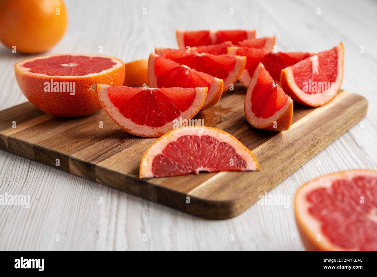 Organic Red Ruby Grapefruit on a Wooden Board, side view. Close-up. Stock Photo