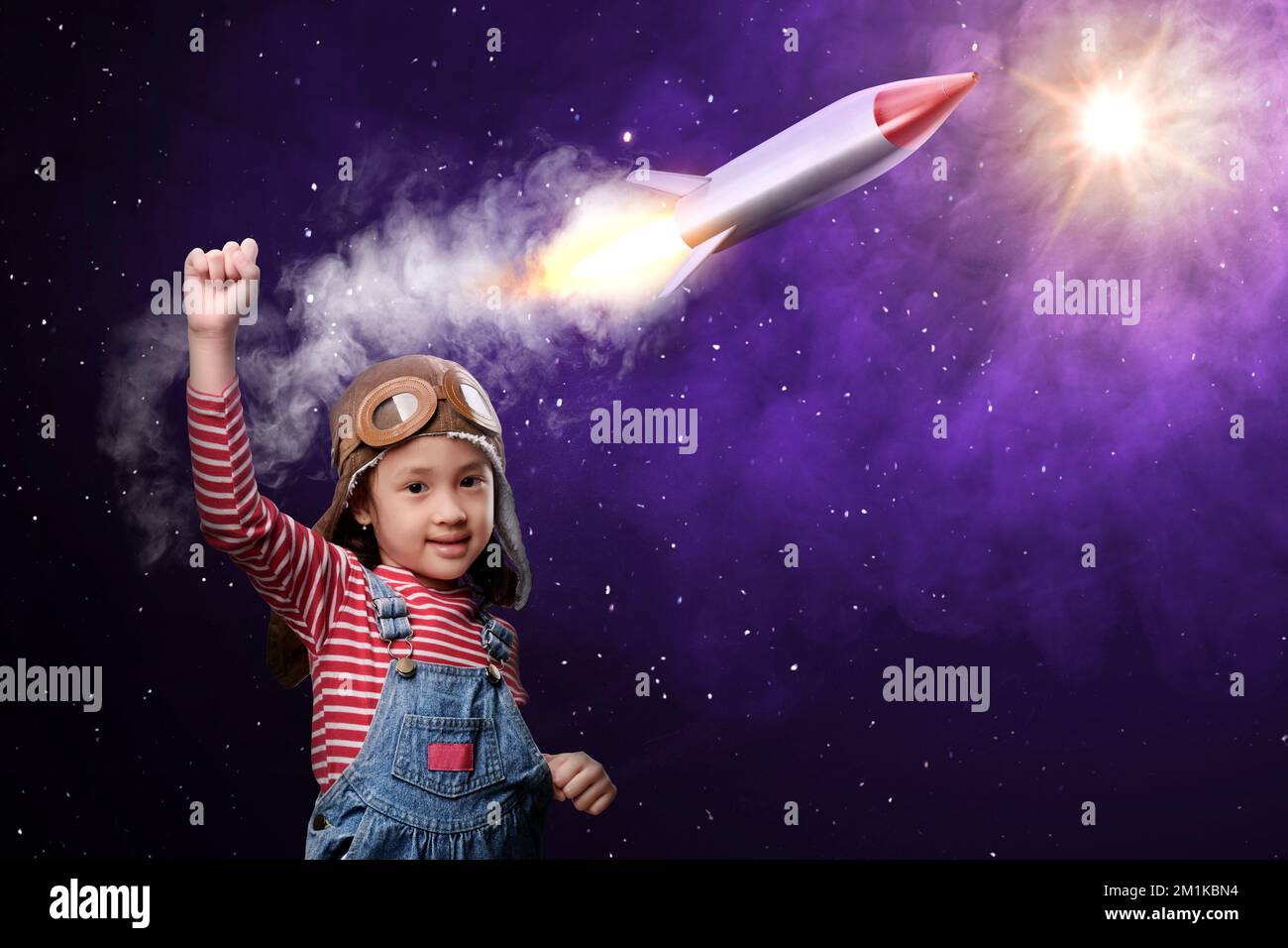 Asian little girl dreaming about flying a rocket. National Science Day Stock Photo