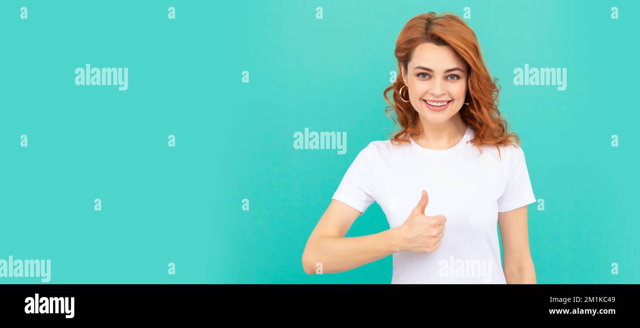 Woman isolated face portrait, banner with copy space. pretty look of young girl. portrait of redhead lady on blue background. thumb up. Stock Photo