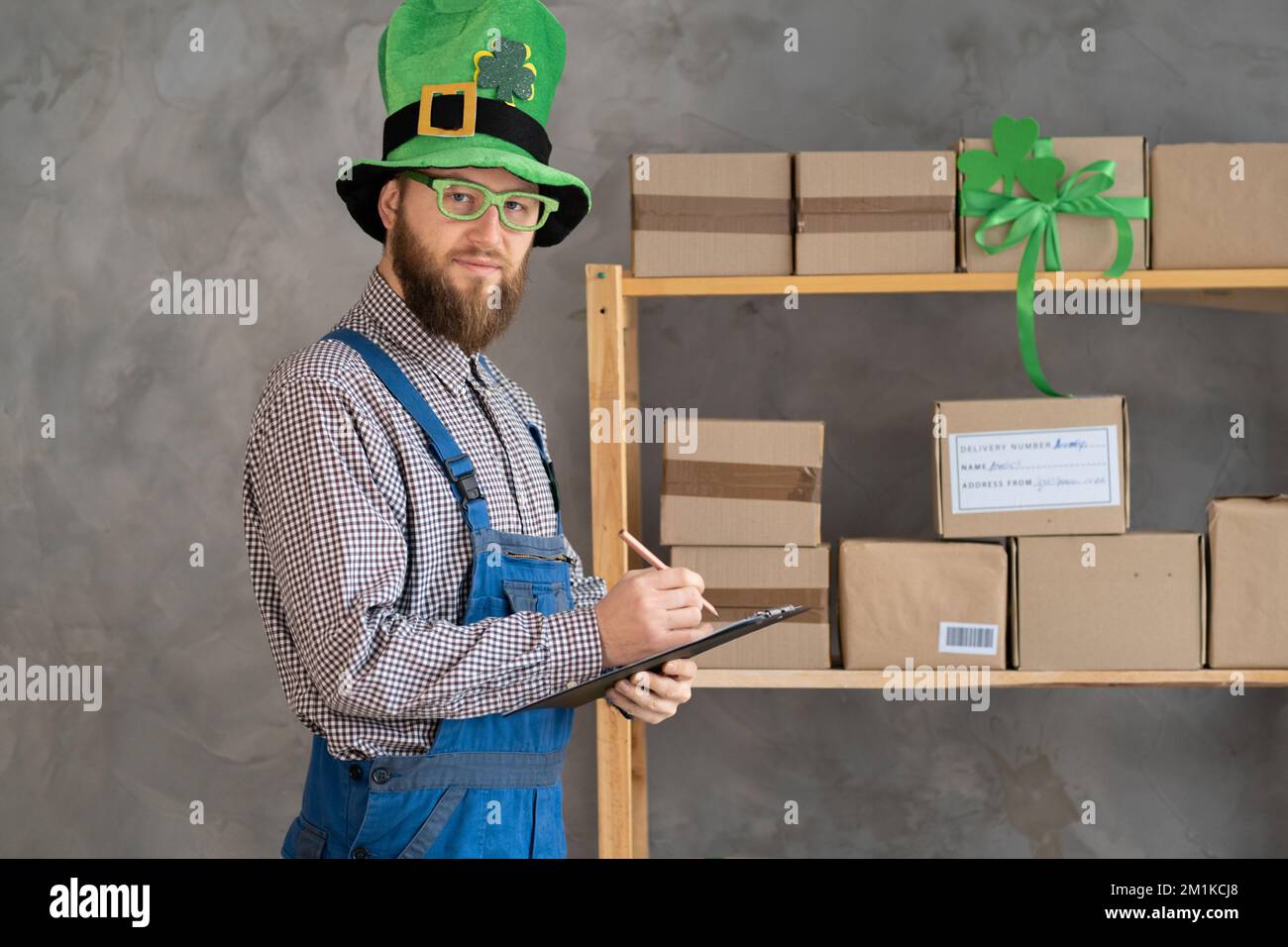 Young delivery man leaving parcel box on the floor at gate wearing