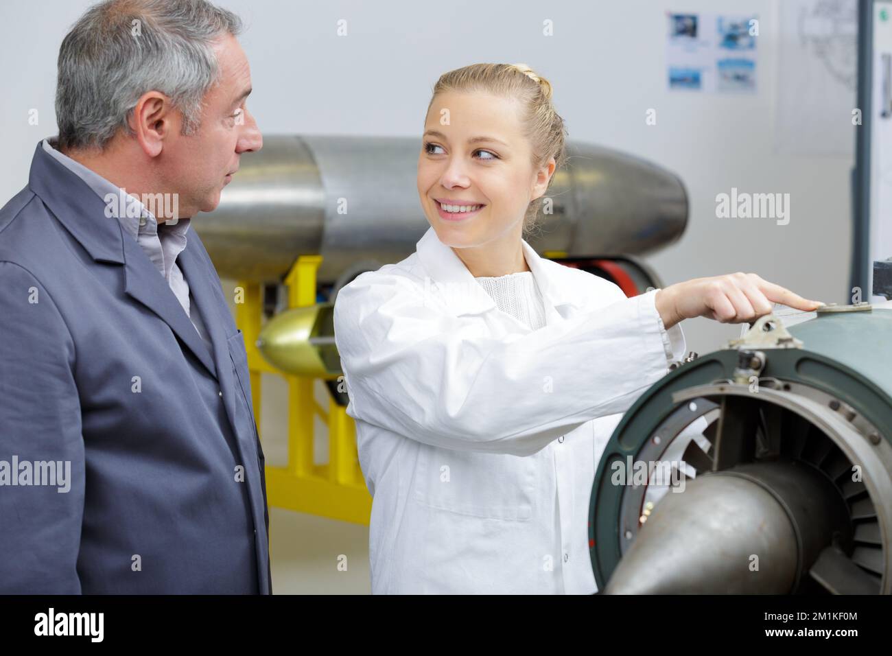 aero engineer and apprentice working in hangar Stock Photo